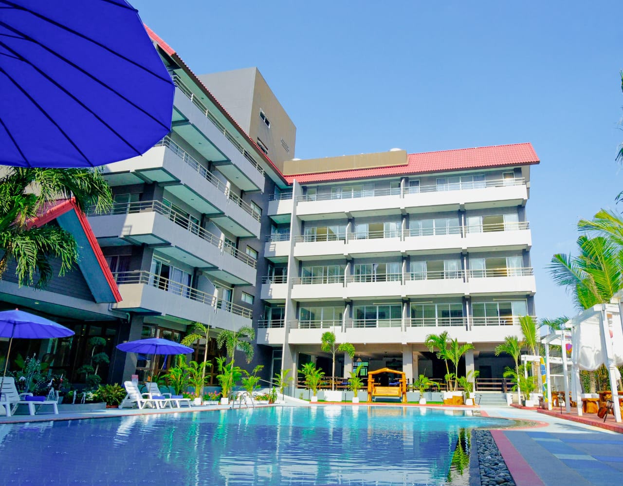 Hotel exterior with pool during the day — The Holiday Resort Pattaya